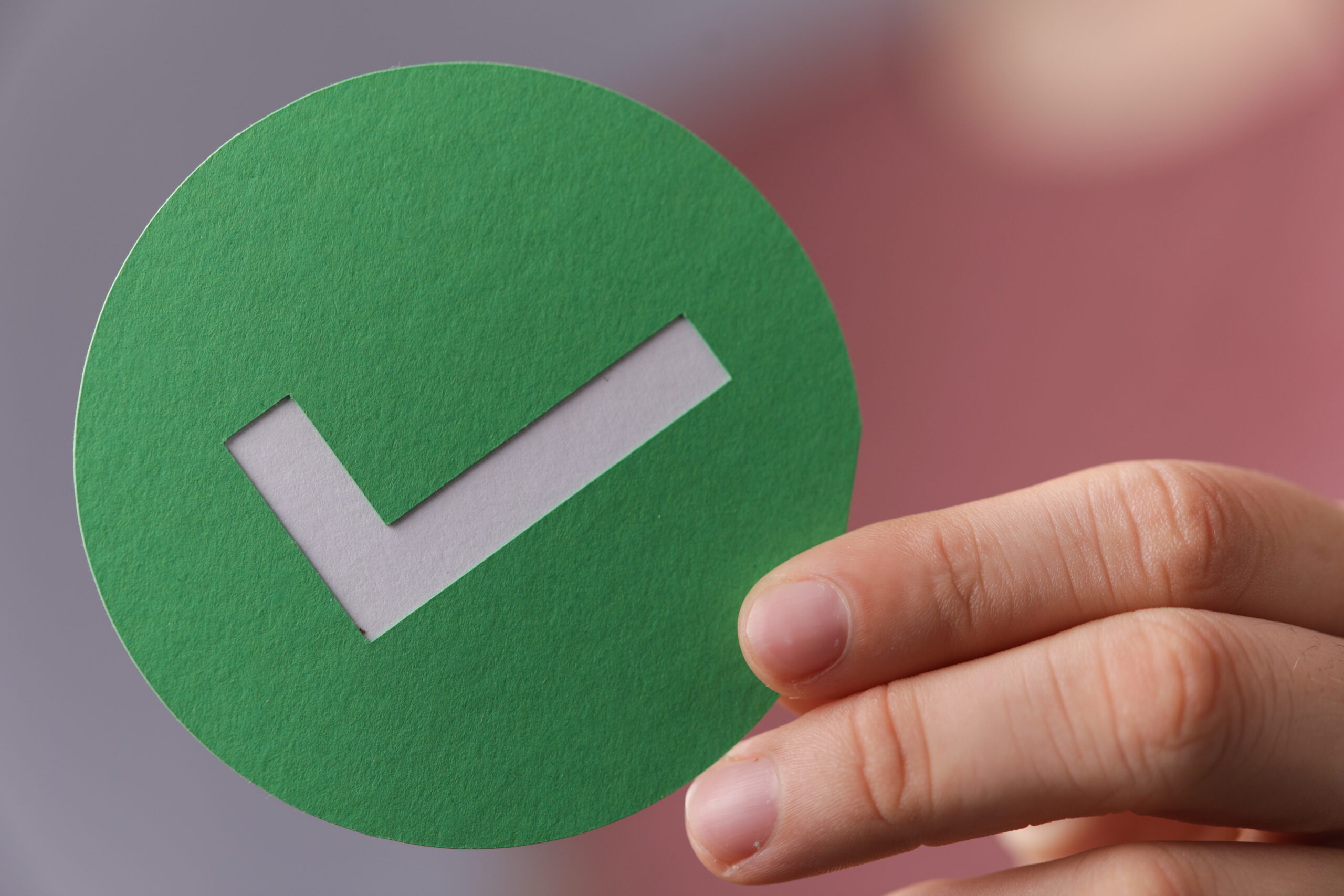 Hand holding a green checkmark